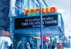A view of the Apollo theater with a street vendor beside it.